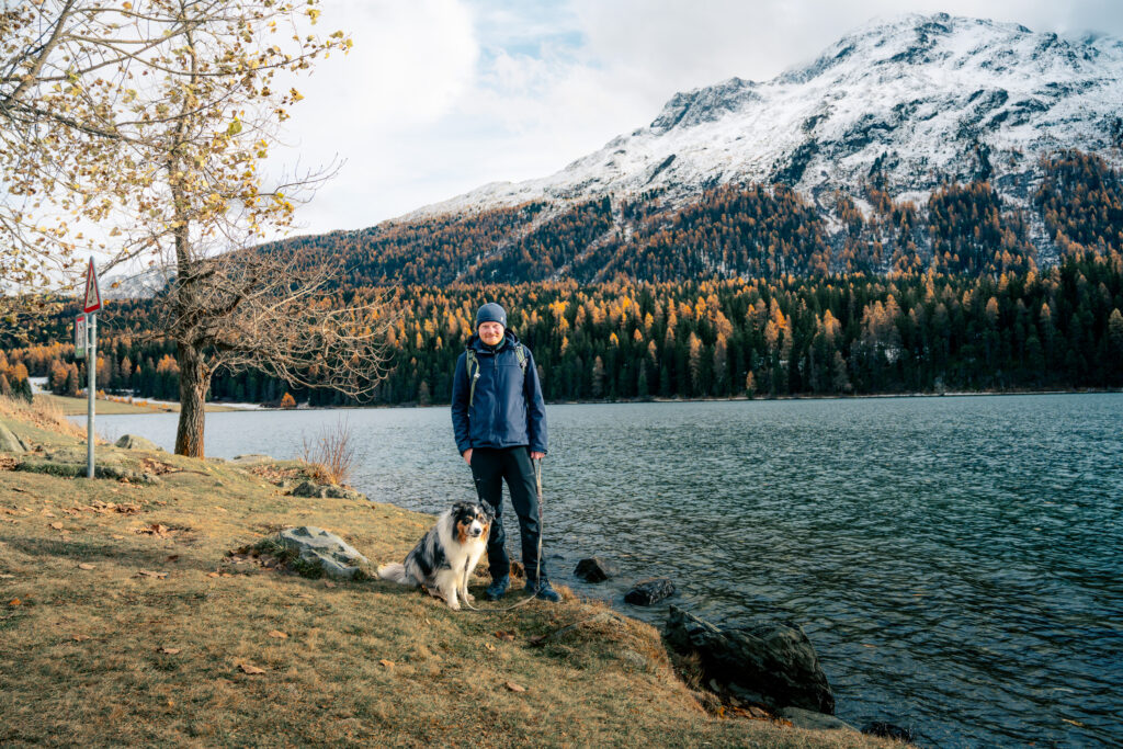 Person mit Hund in Natur vor Berg und See Herbst